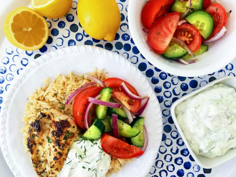 Simple Greek Grilled Chicken Rice Bowl served with a fresh and vibrant salad and delicious tzatziki!