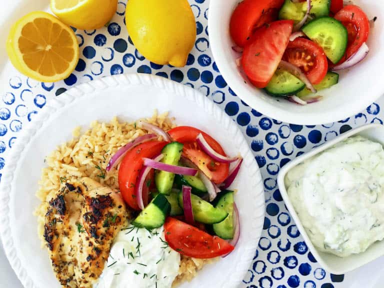 Simple Greek Grilled Chicken Rice Bowl served with a fresh and vibrant salad and delicious tzatziki!