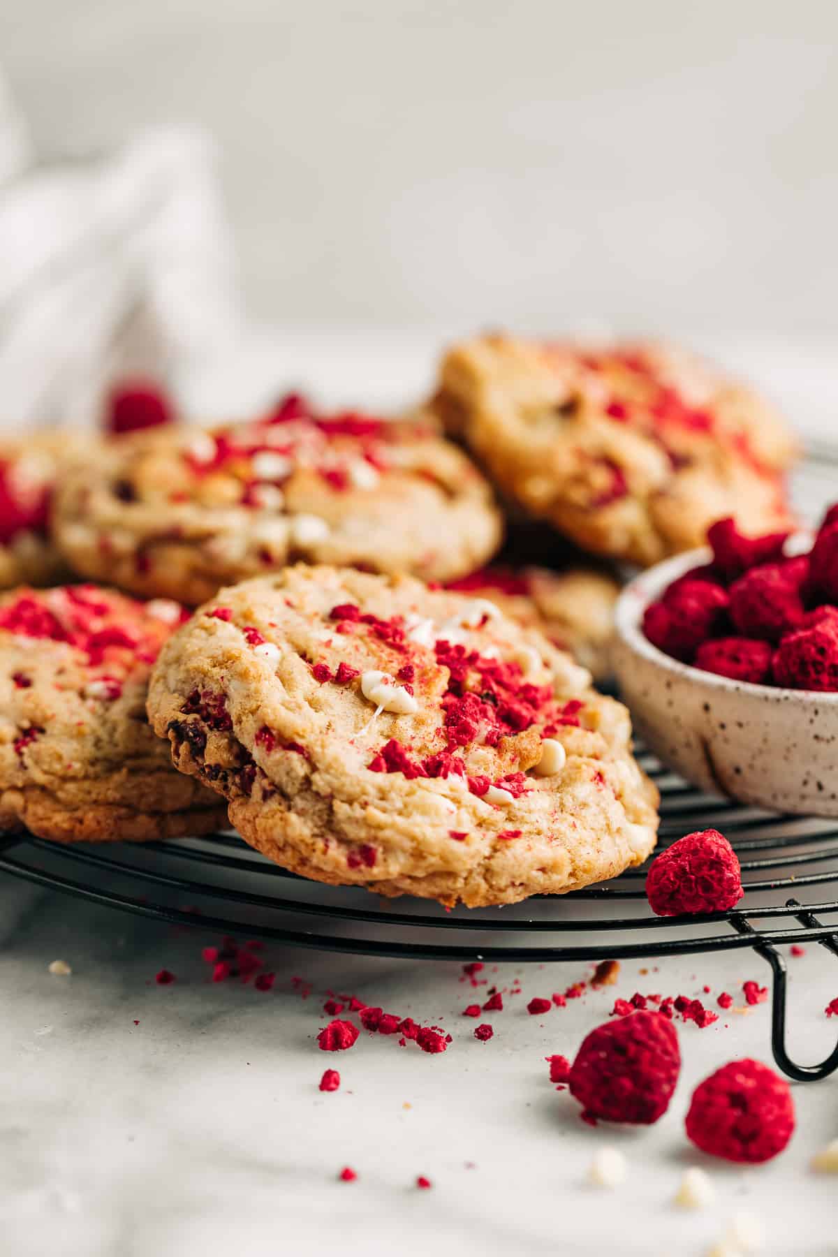 Raspberry white chocolate chip cookies on a wire cooling rack.