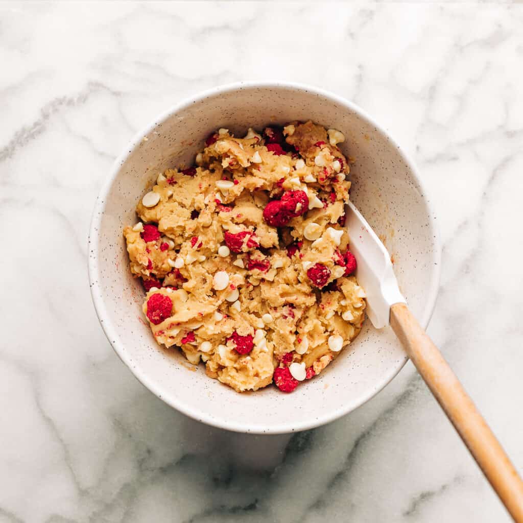 Raspberry white chocolate chip cookie dough in a mixing bowl.