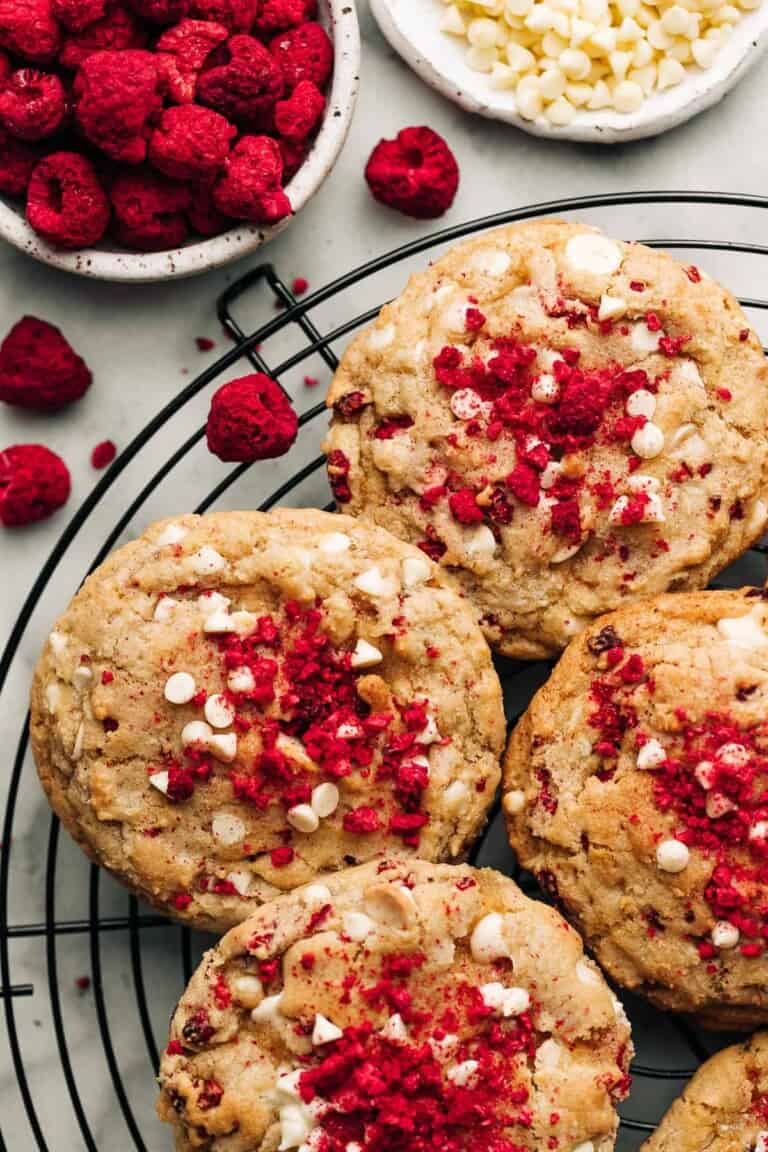 Raspberry white chocolate chip cookies on a black wire rack.