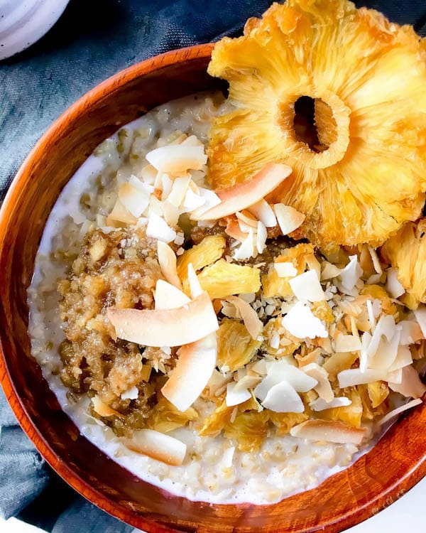 10 minute breakfast - Tropical Steel Cut Oats topped with toasted coconut, dried pineapple, and a date "caramel" sauce. (GF, Vegan, Refined Sugar Free)