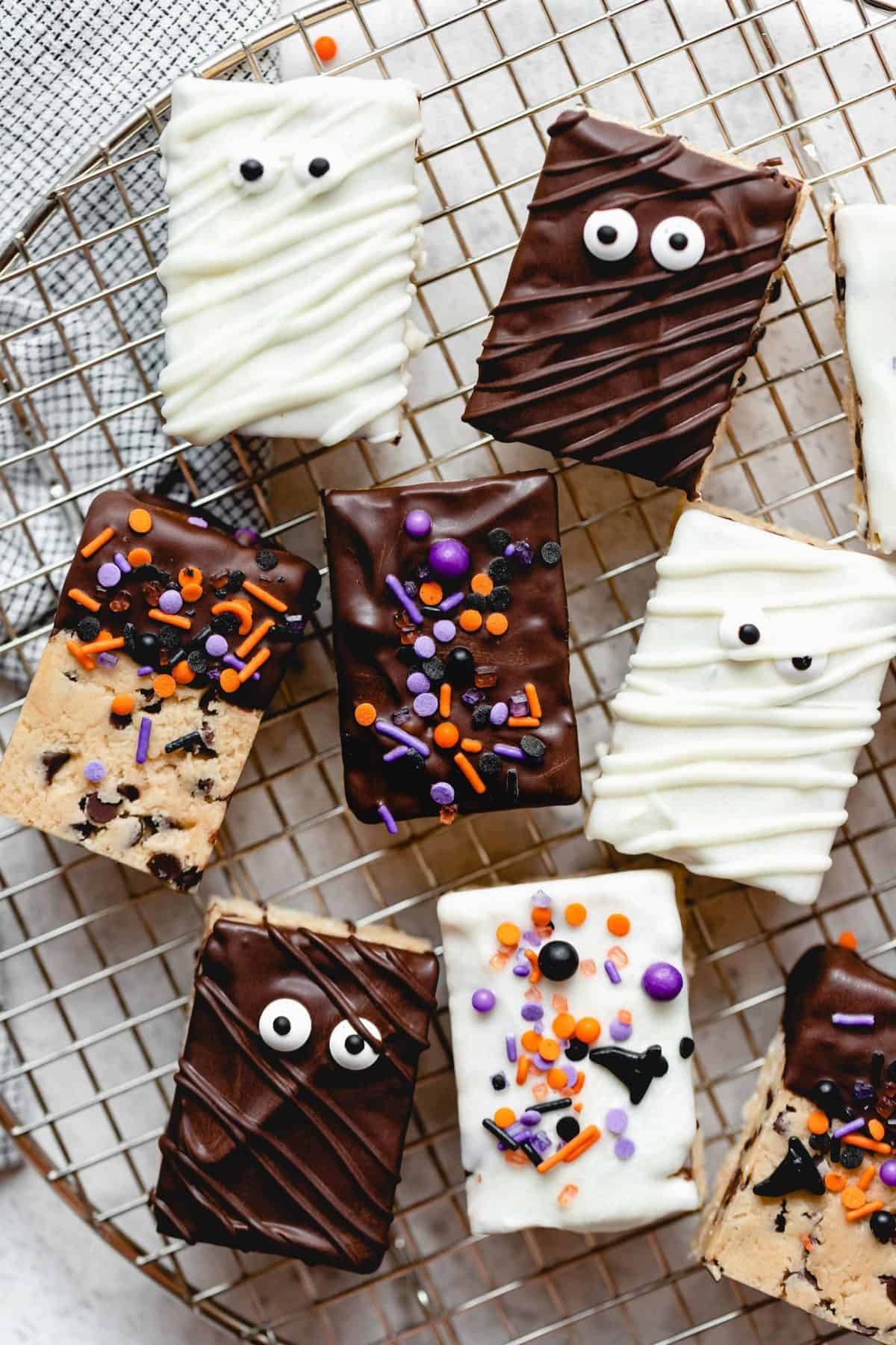 Halloween themed cookie dough rice krispie treats on a wire rack