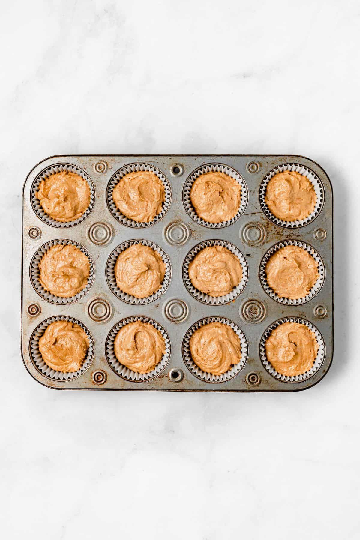 pumpkin muffin batter in muffin pan