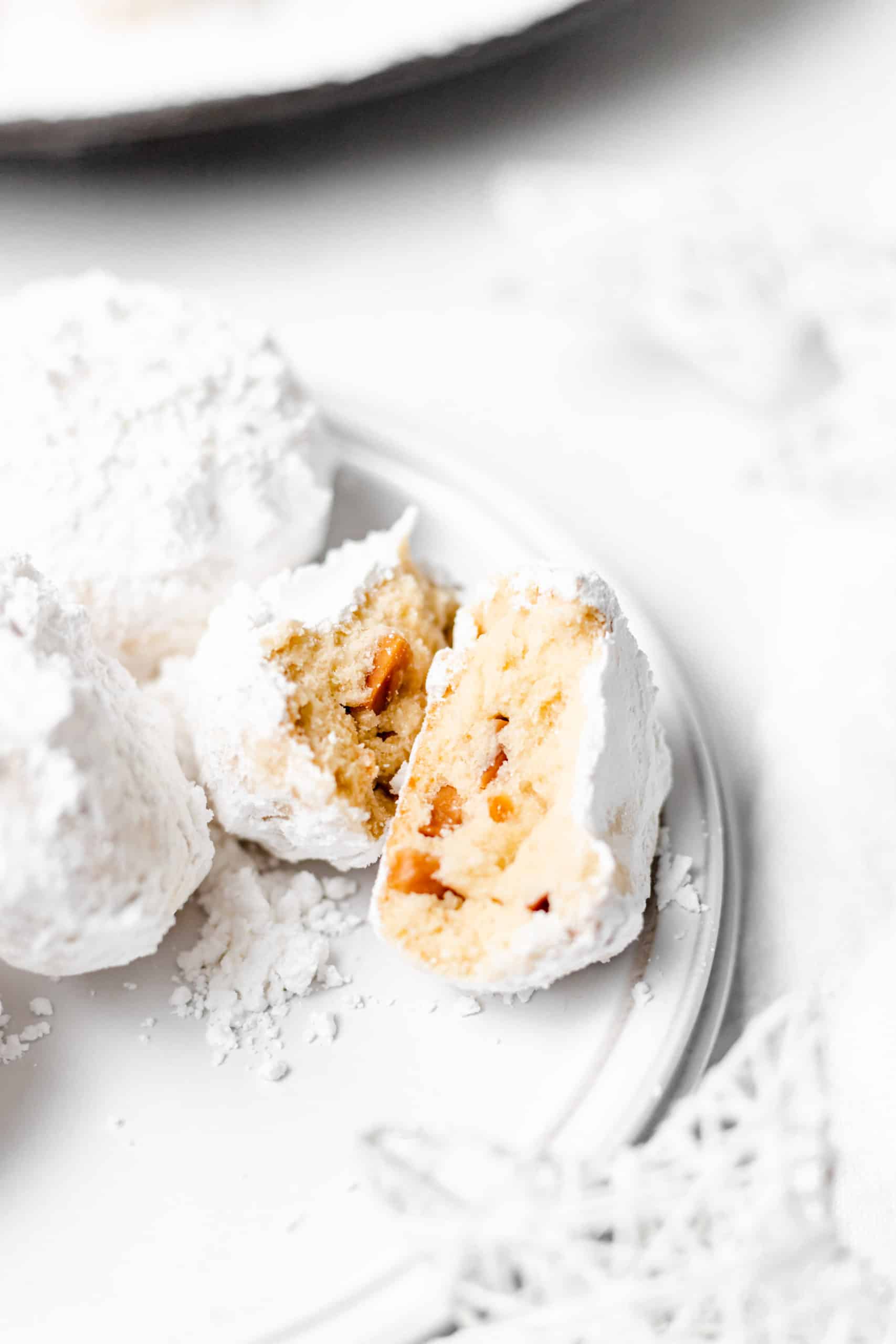 kourabiedes broke in half on a white plate.