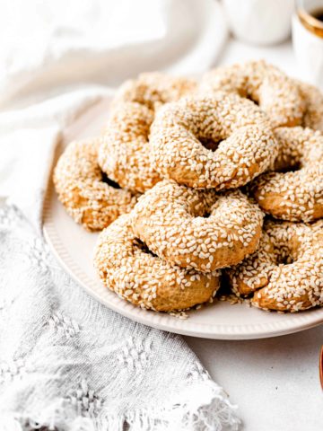 olive oil and sesame seed cookies stacked on a plate