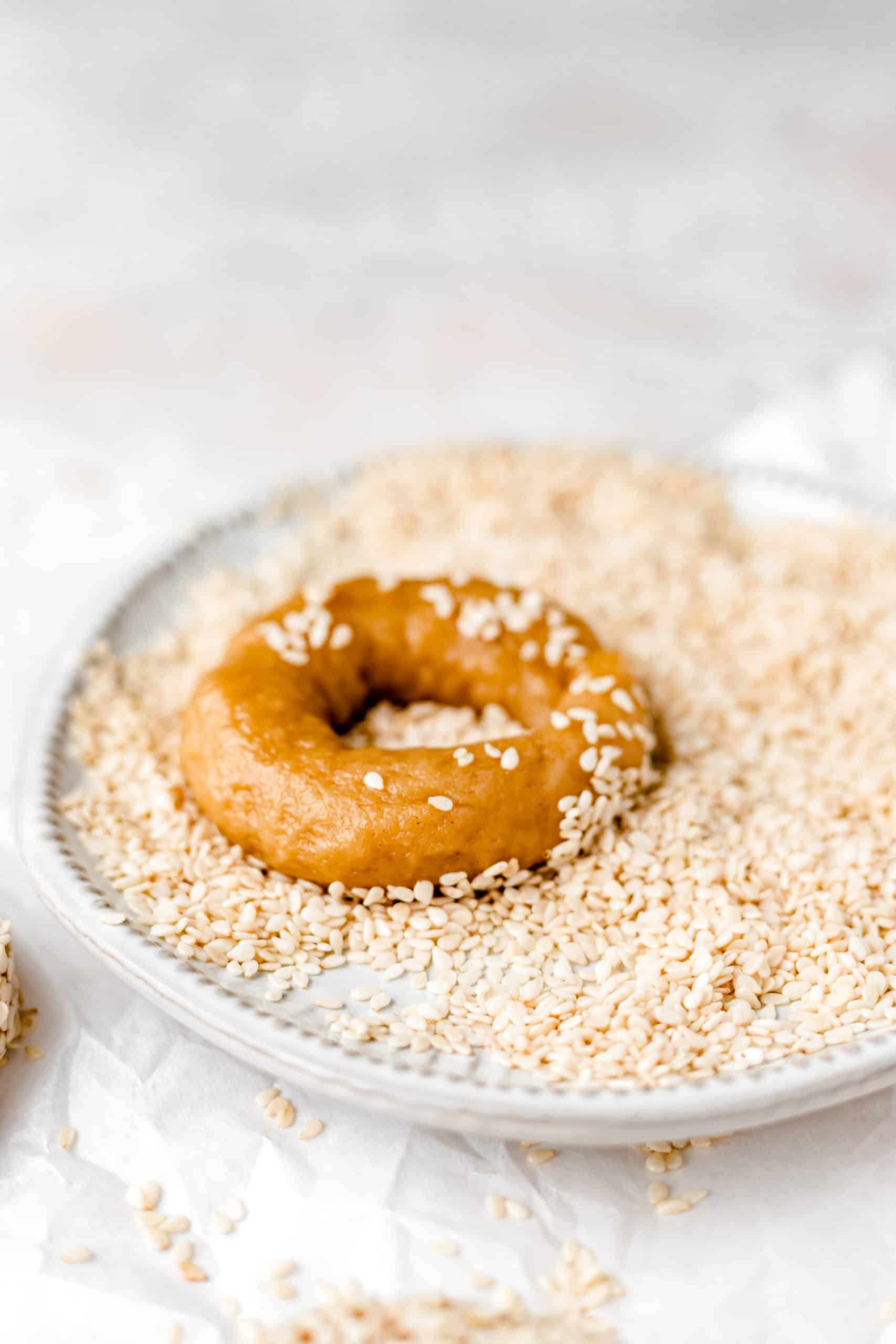 olive oil and orange cookie in a plate of sesame seeds