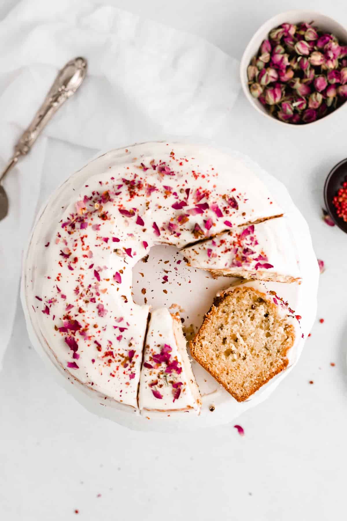 Rose and Pink Peppercorn Cake is delicious, unique, and so pretty! The cake is topped with a cream cheese glaze and finished with crushed pink peppercorns and dried rose buds.