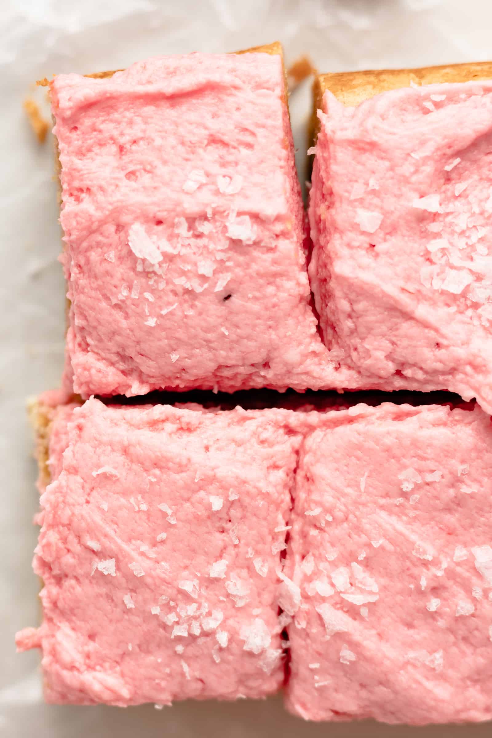 Sweet and chewy blondies with fluffy pink frosting
