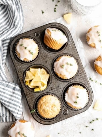Lemon thyme muffins with glaze in a muffin tin.