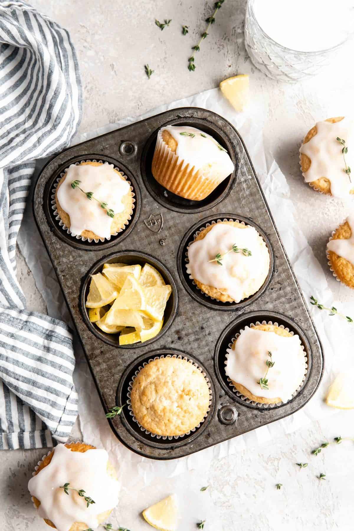 Lemon thyme muffins with glaze in a muffin tin.