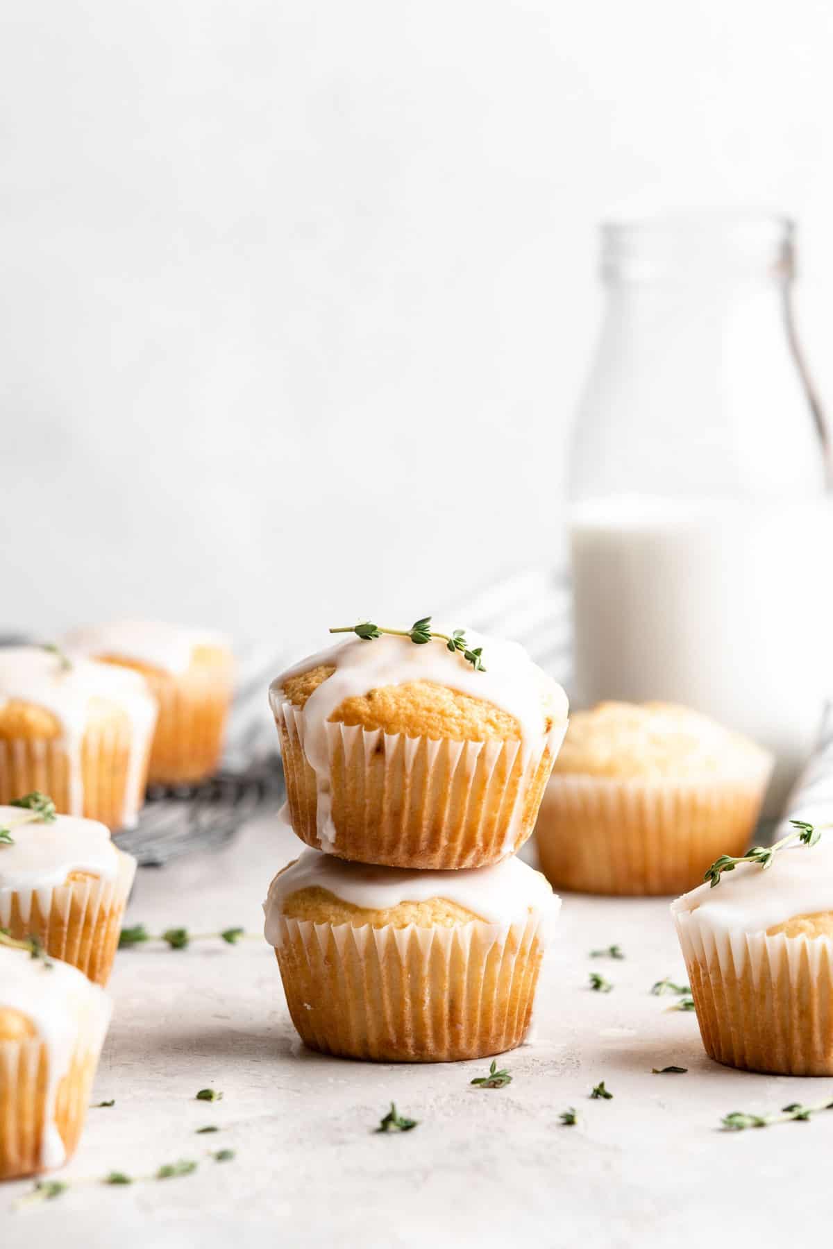 Two lemon thyme muffins with glaze stacked on top of each other. 