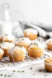 Lemon thyme muffins with glaze on a wire cooling rack.