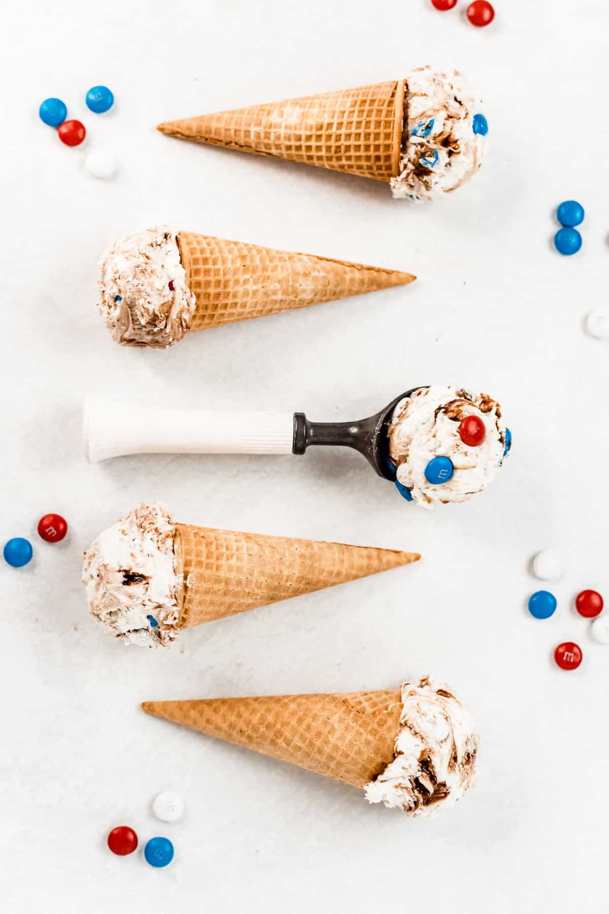 Creamy vanilla ice cream with fudgy chocolate swirls and milk chocolate M&M’S will be your new summer dessert! This No-Churn Fudge Ripple M&M Ice Cream is rich, smooth, and only takes a few minutes to prepare. #icecream #nochurnicecream #4thofjulyrecipe