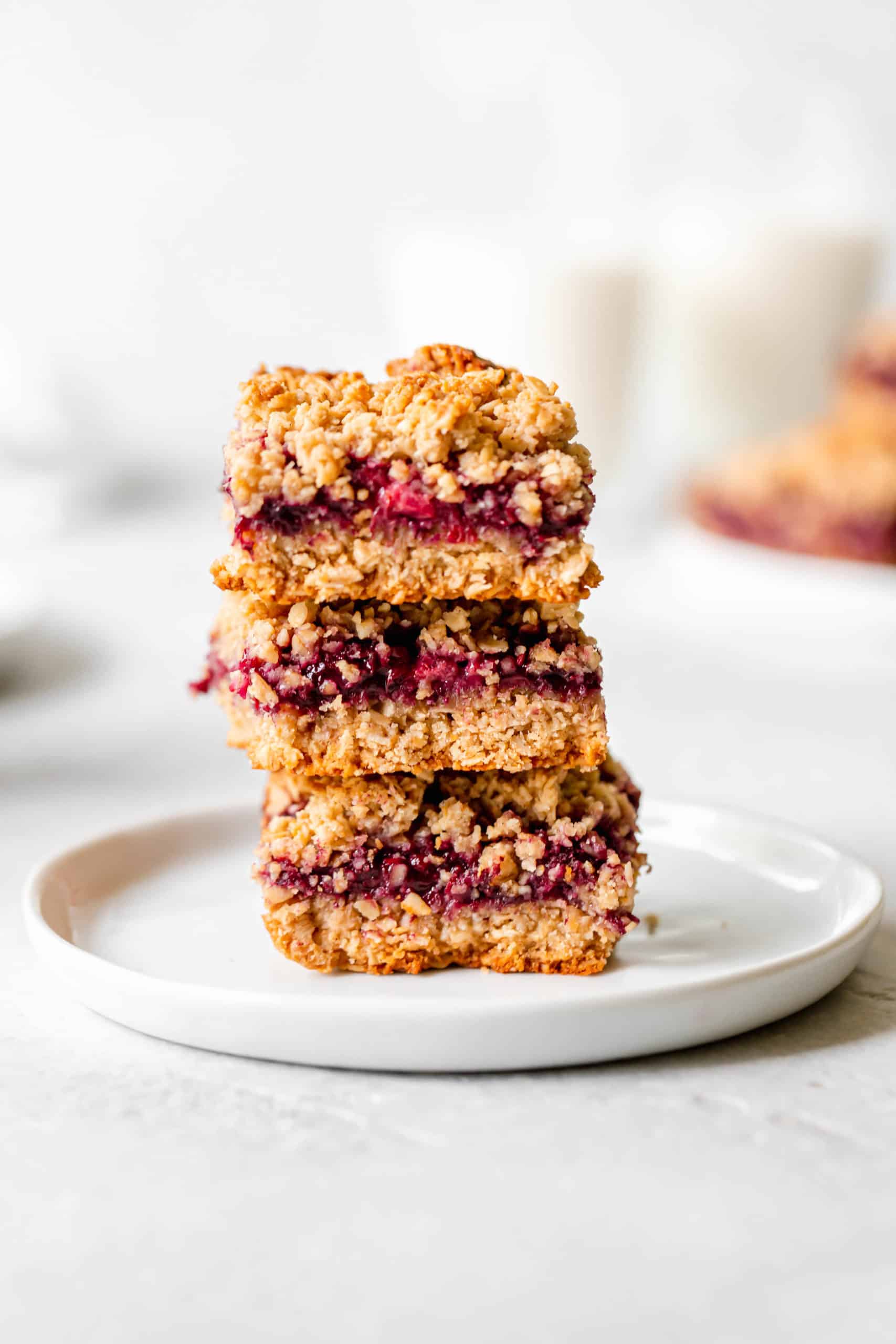 healthy blackberry crumble bars stacked vertically on a plate