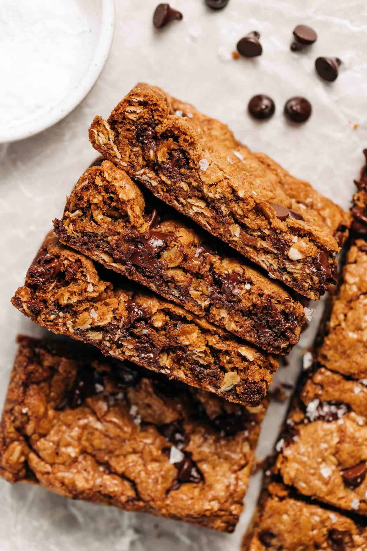 Oatmeal chocolate chip cookie bars on wax paper.