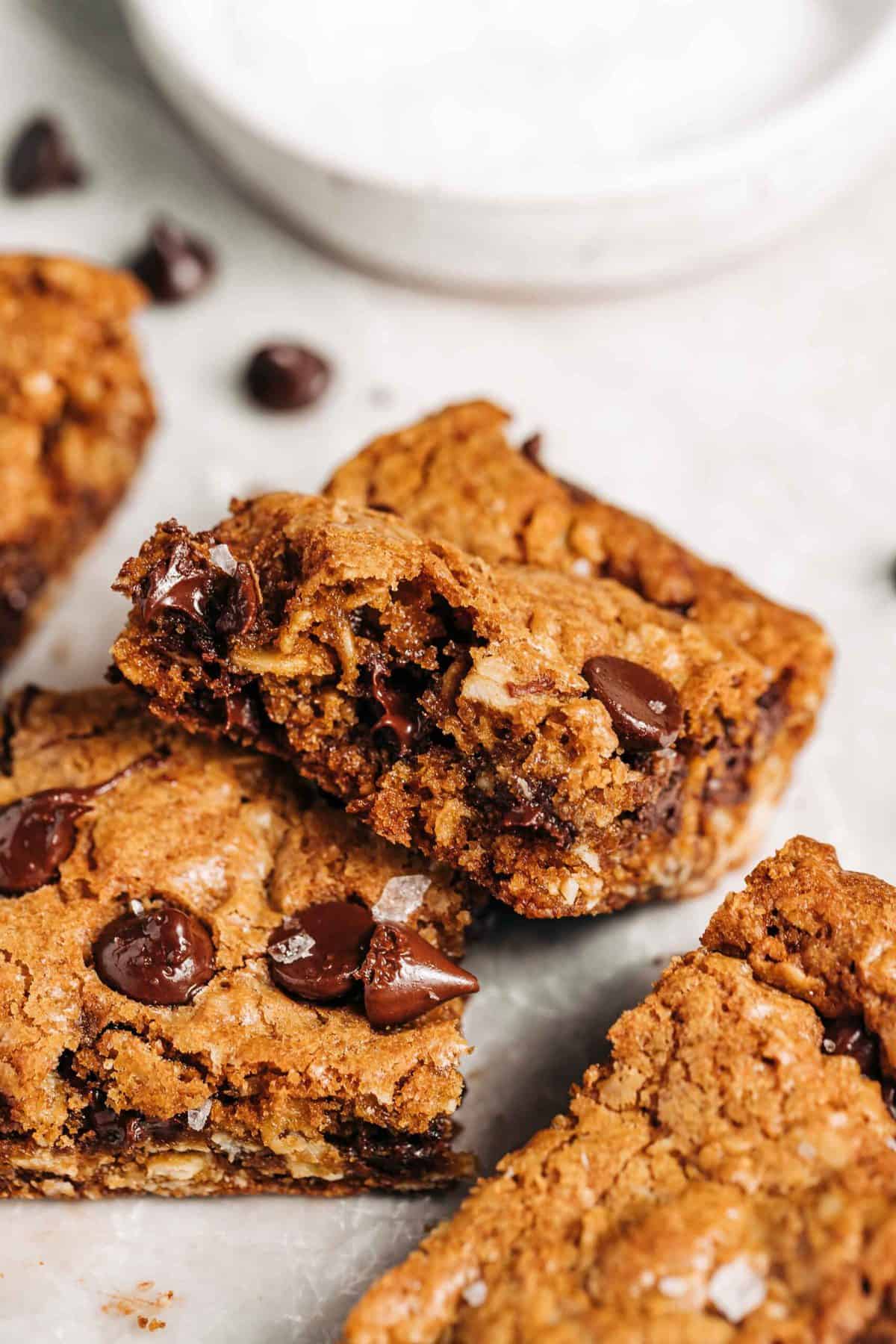 Oatmeal chocolate chip cookie bars on wax paper.