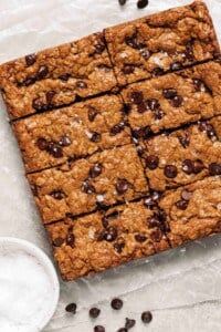 Oatmeal chocolate chip cookie bars on wax paper.