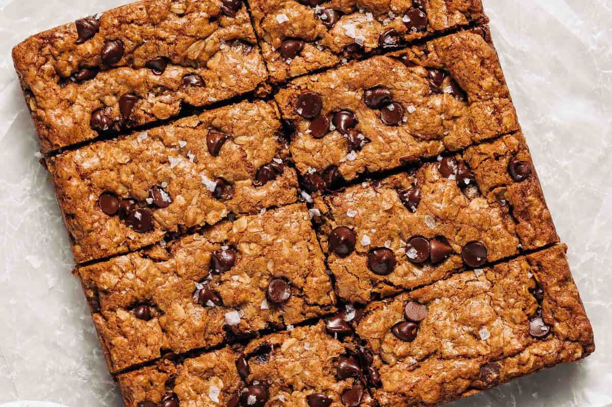 Oatmeal chocolate chip cookie bars on wax paper.