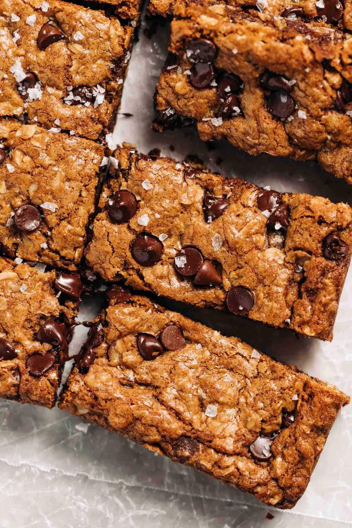 Oatmeal chocolate chip cookie bars on wax paper.