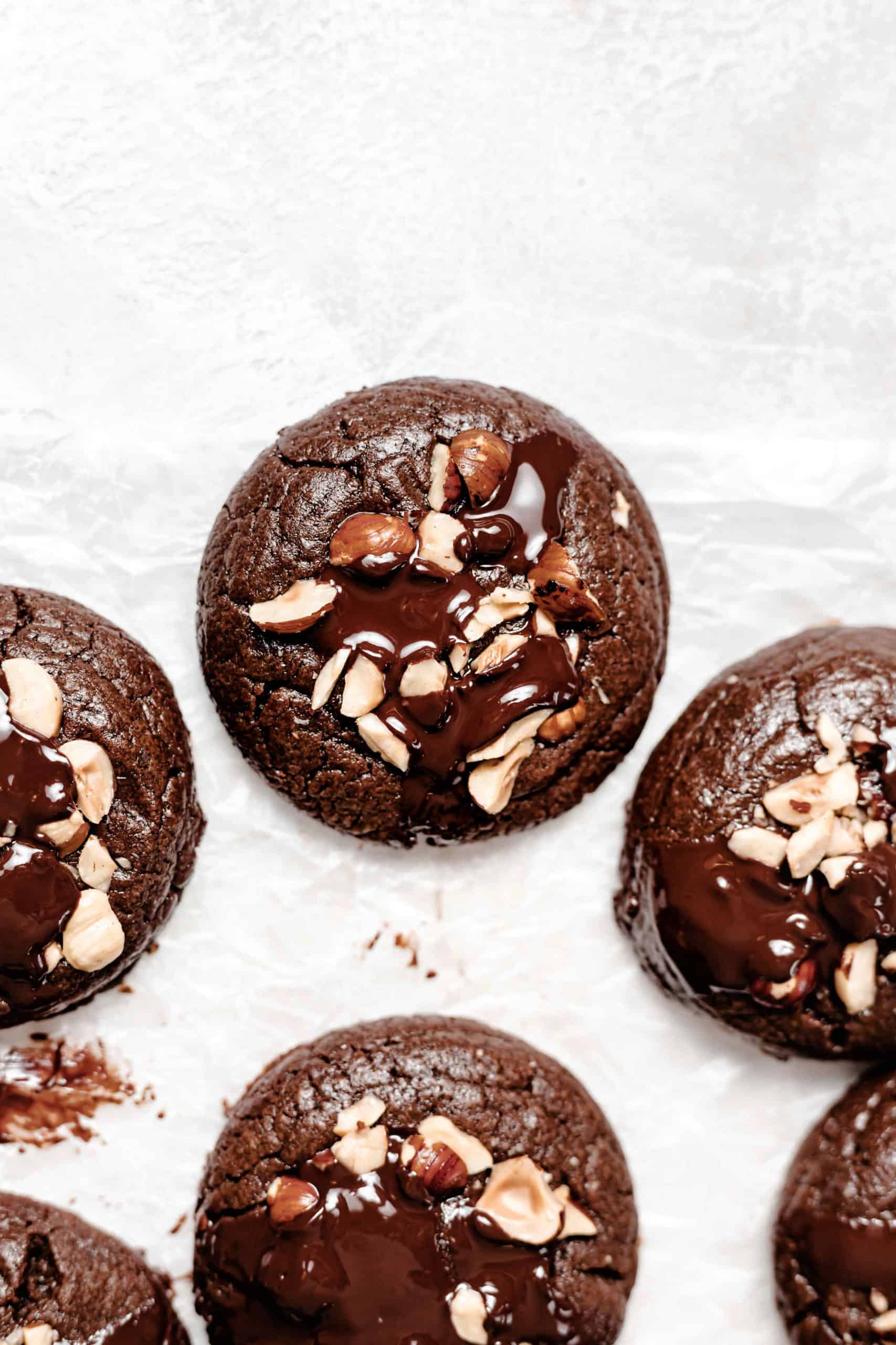 chocolate hazelnut brownie cookies with puddles of chocolate on parchment paper