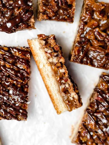 chocolate drizzled pecan shortbread bars on parchment paper