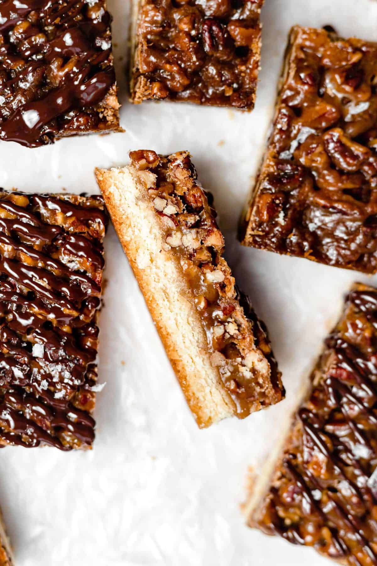 chocolate drizzled pecan shortbread bars on parchment paper
