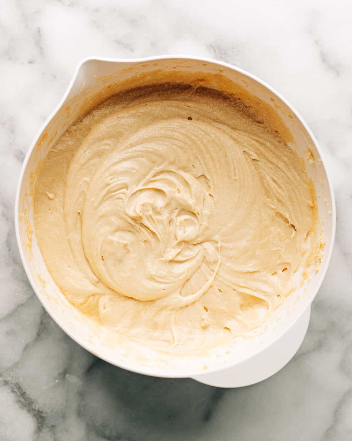 butter, sugar, and eggs combined in a mixing bowl.