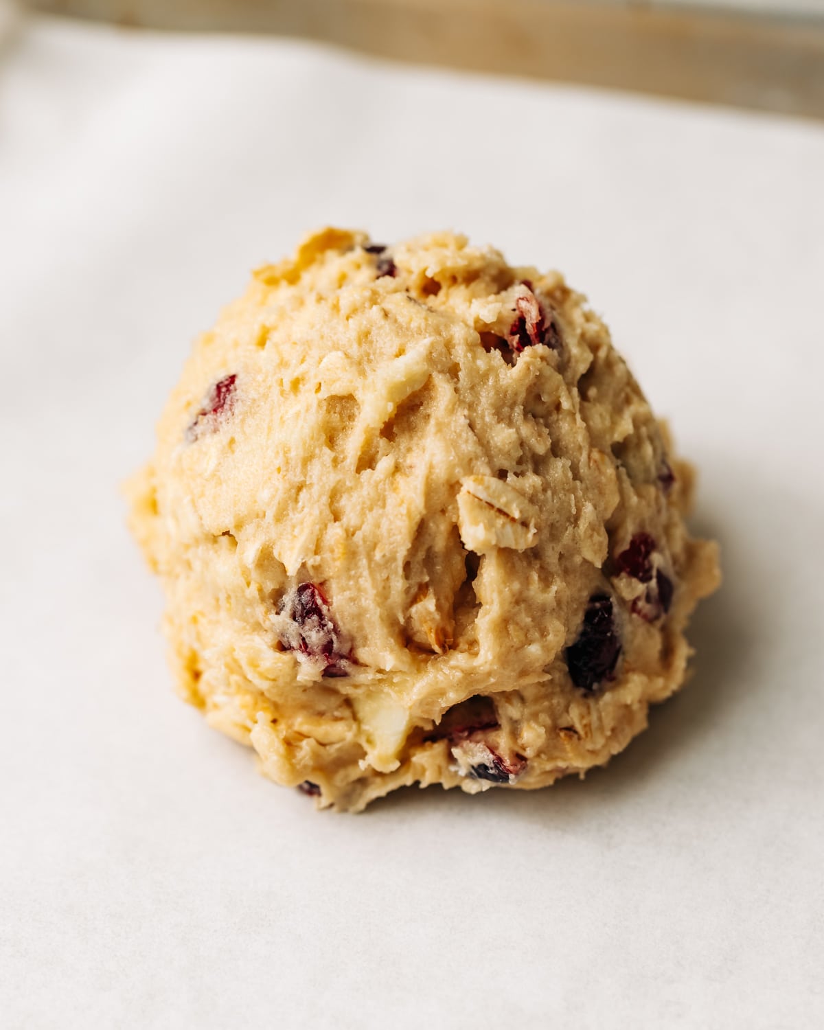 unbaked white chocolate cranberry cookie on a baking sheet.