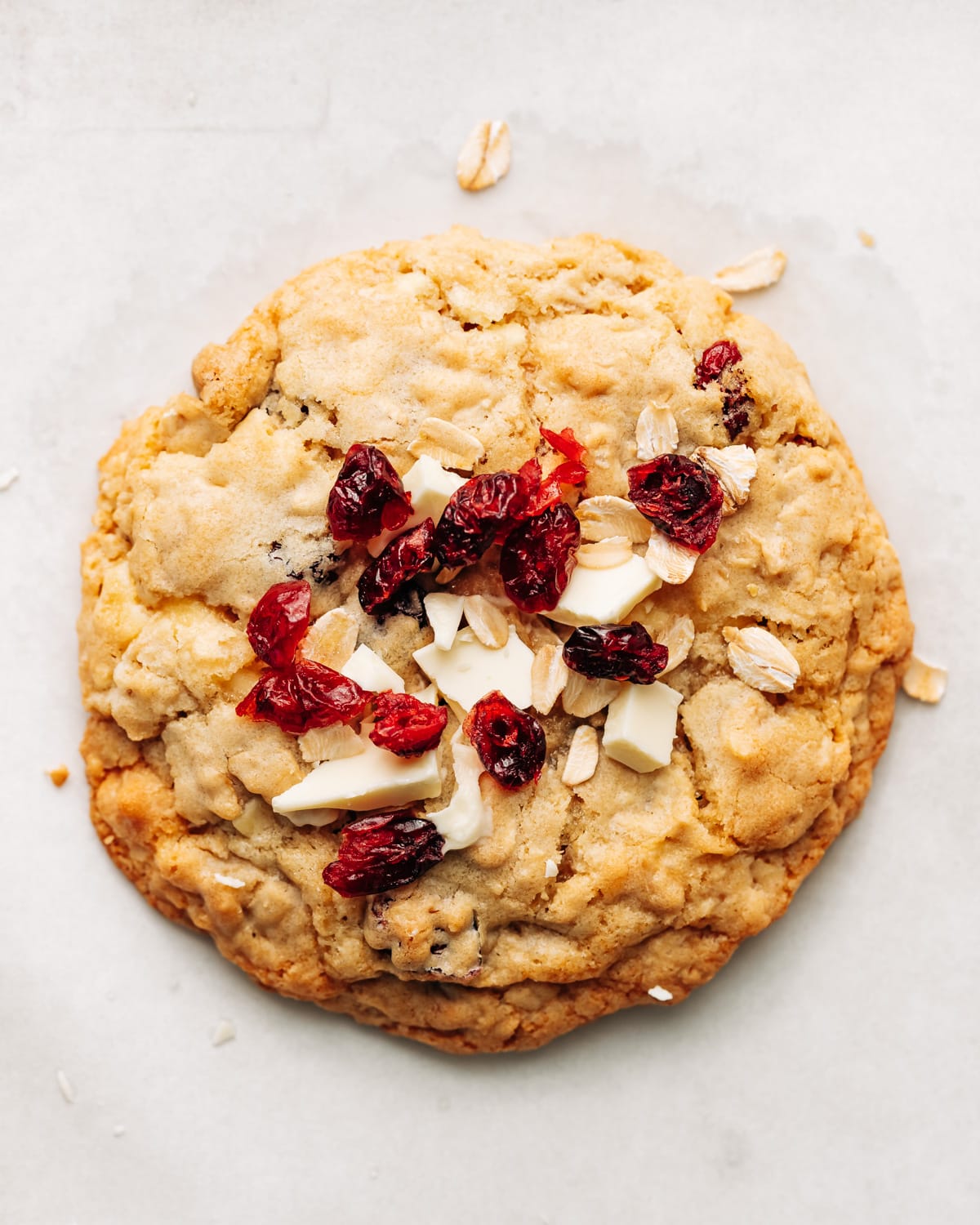 white chocolate cranberry oatmeal cookie on parchment paper.