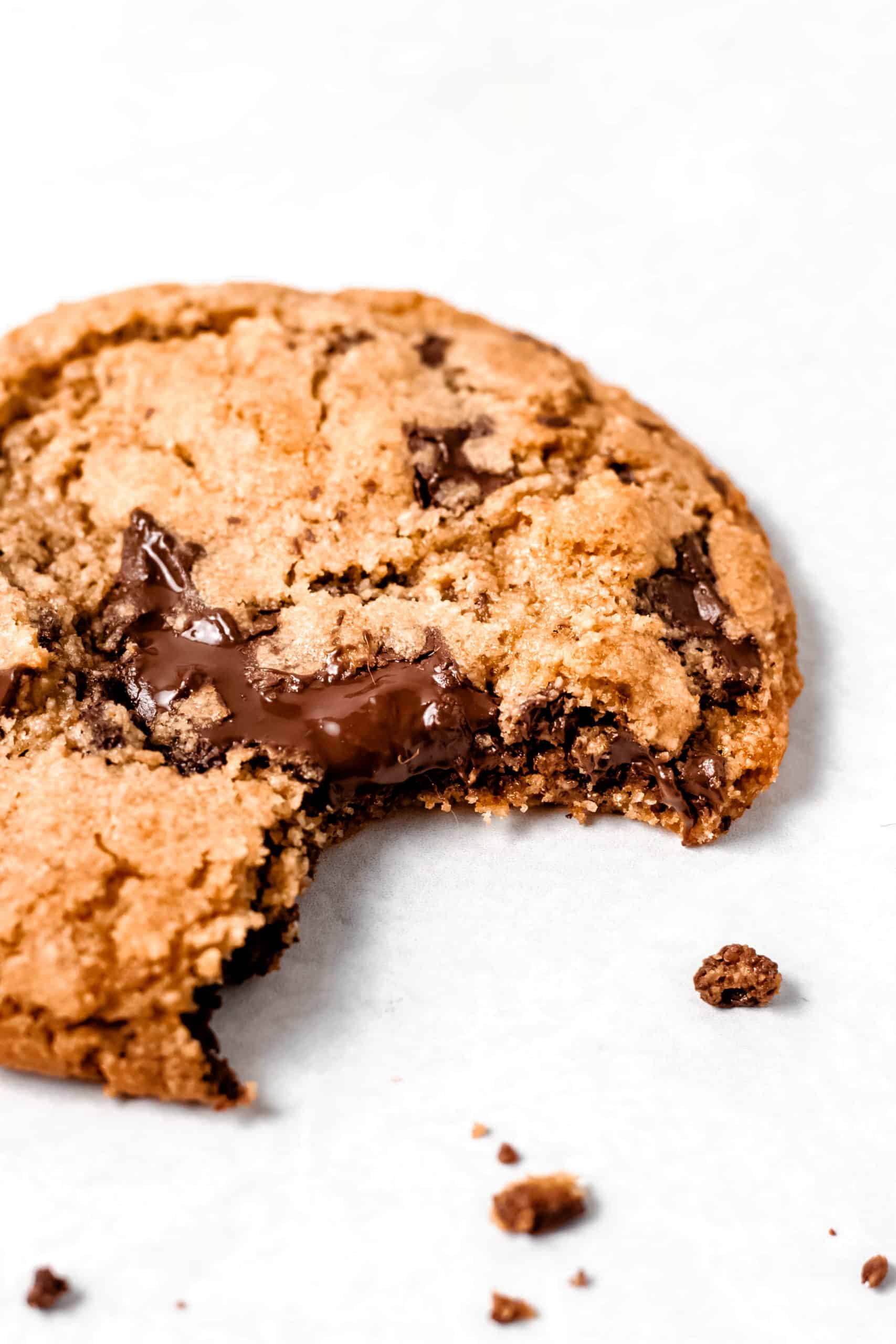 Crisp and chewy gluten free chocolate chip cookie with bite taken out of it