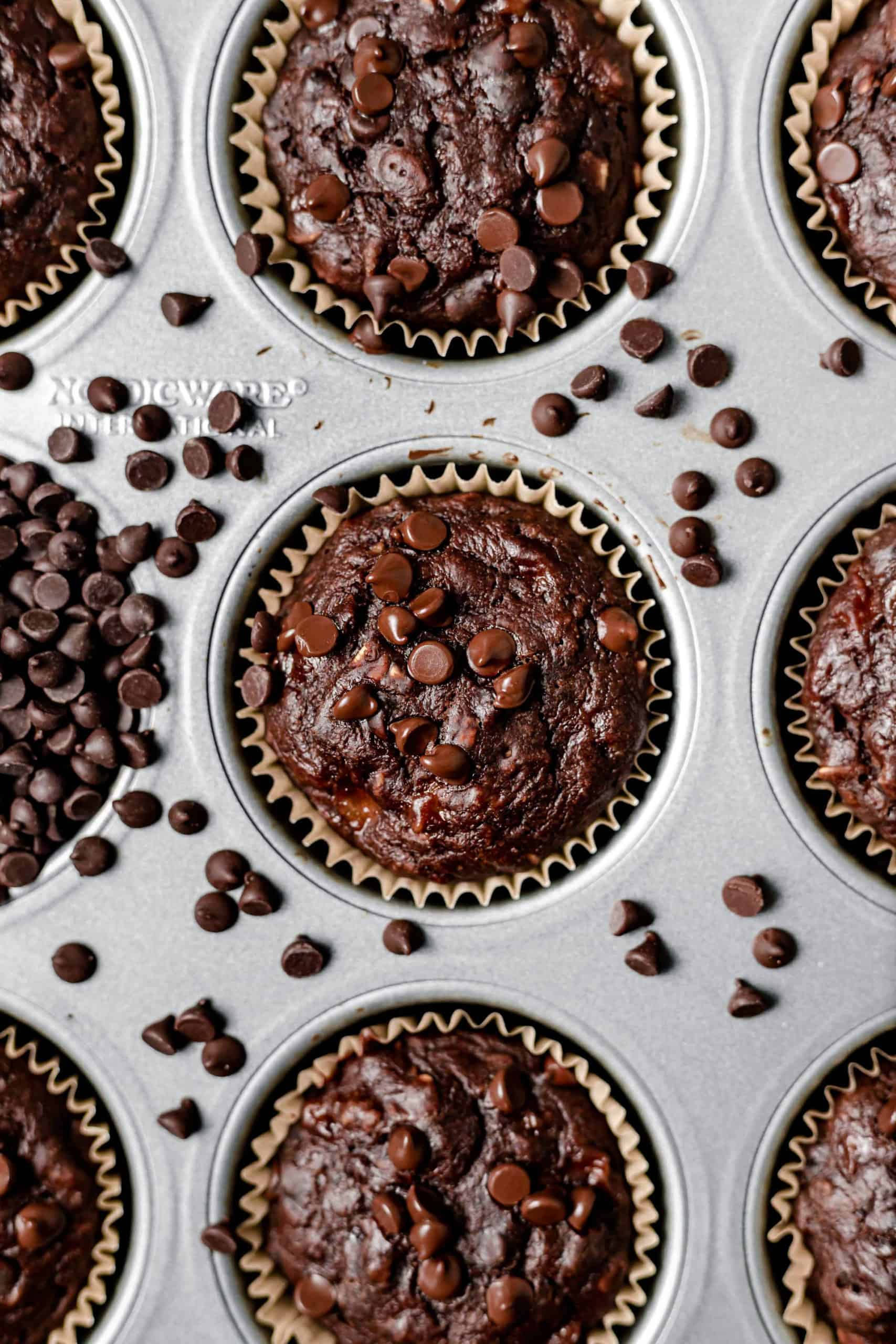 chocolate peanut butter banana muffins in muffin pan with mini chocolate chips