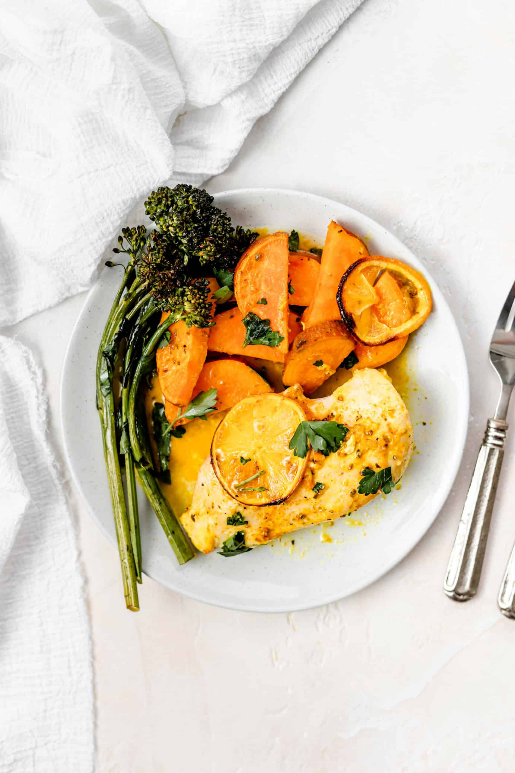 lemon chicken roasted sweet potatoes and broccolini in a plate