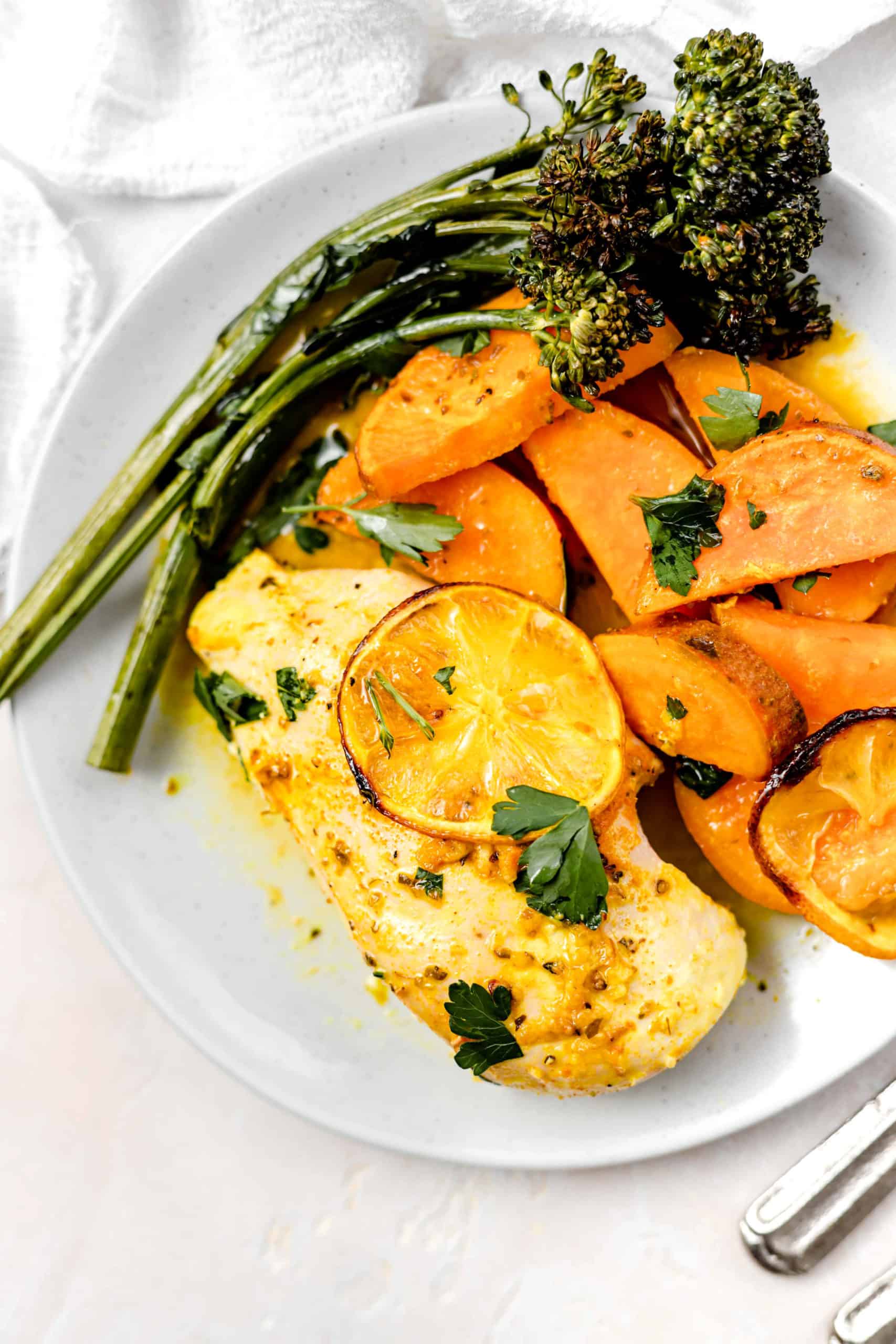 lemon chicken roasted sweet potatoes and broccolini in a plate