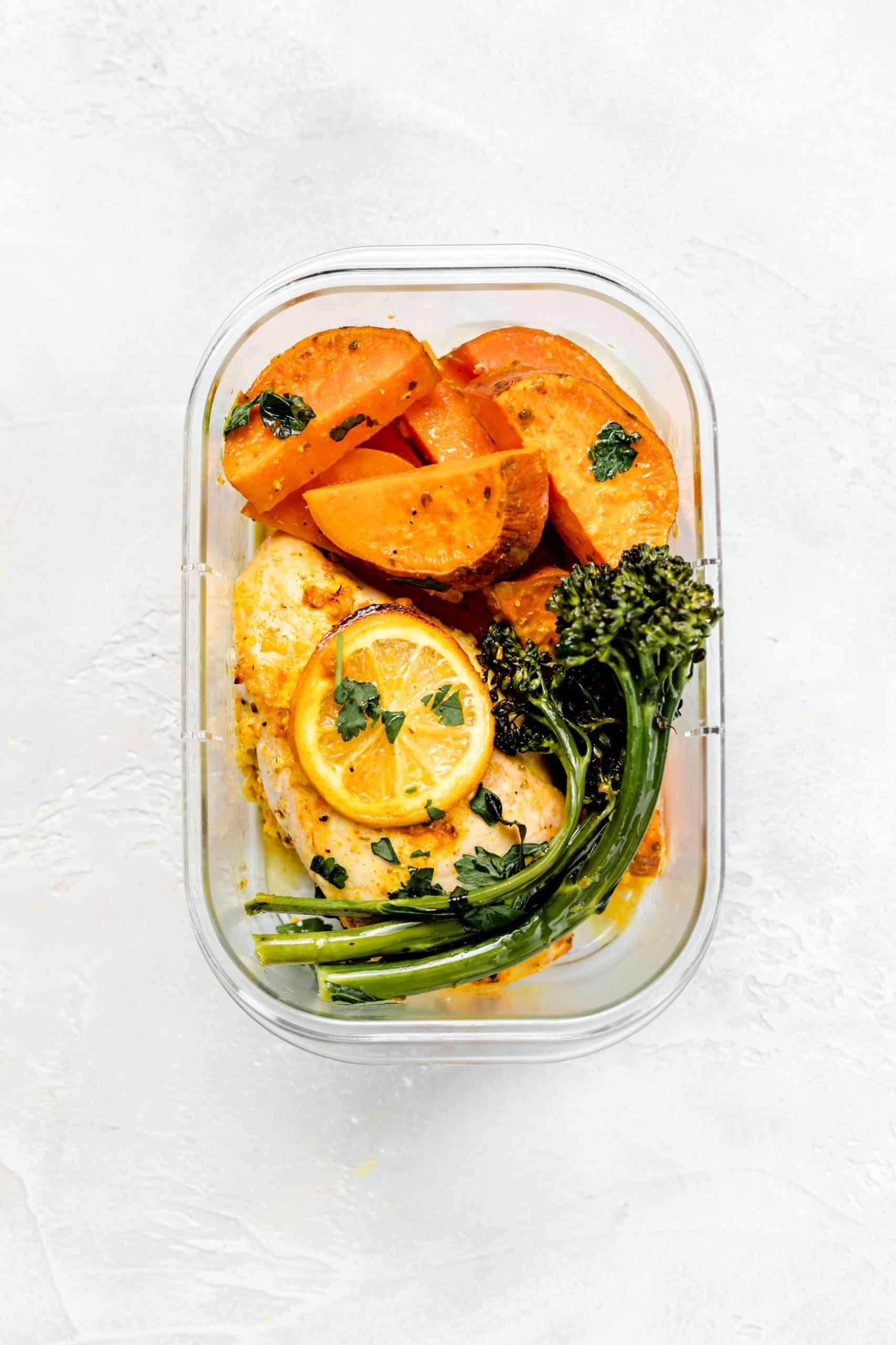 lemon chicken, sweet potatoes, and broccolini in meal prep container