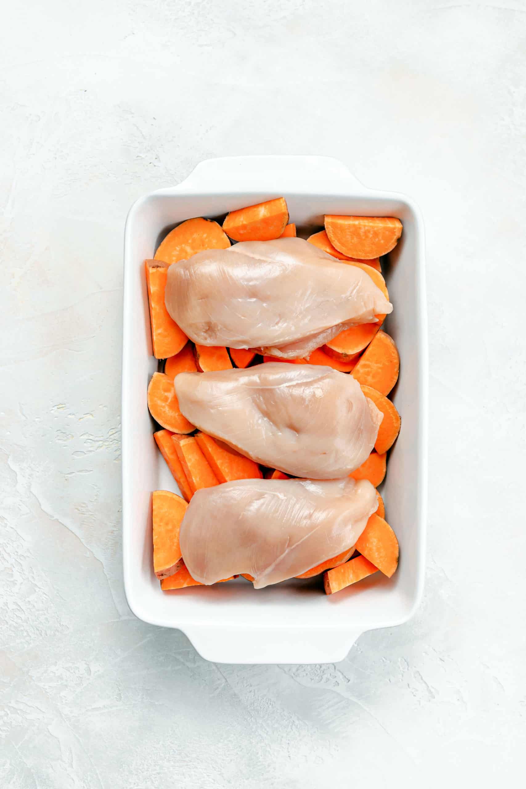sweet potatoes and chicken in roasting pan