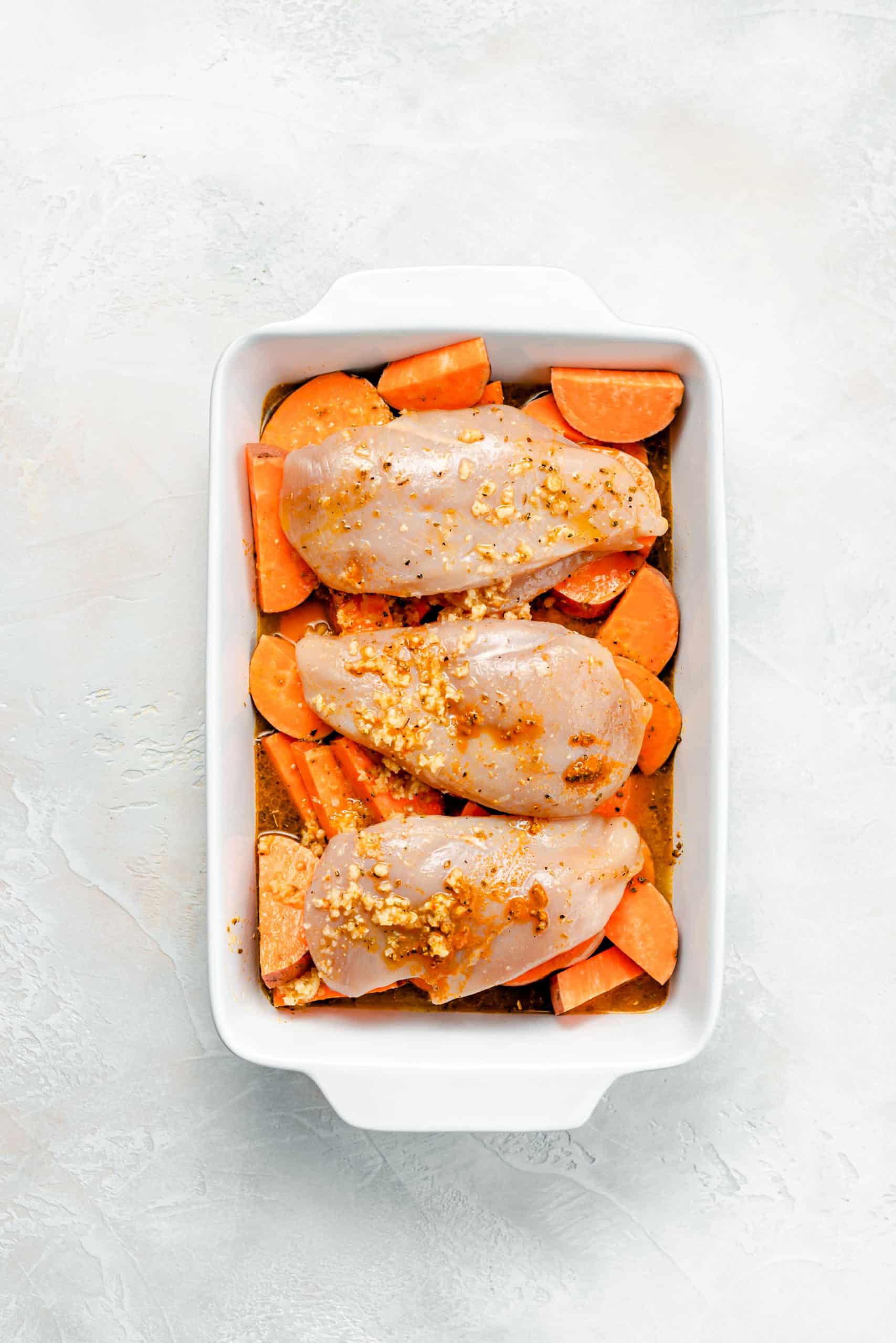 sweet potatoes and chicken breast in roasting pan