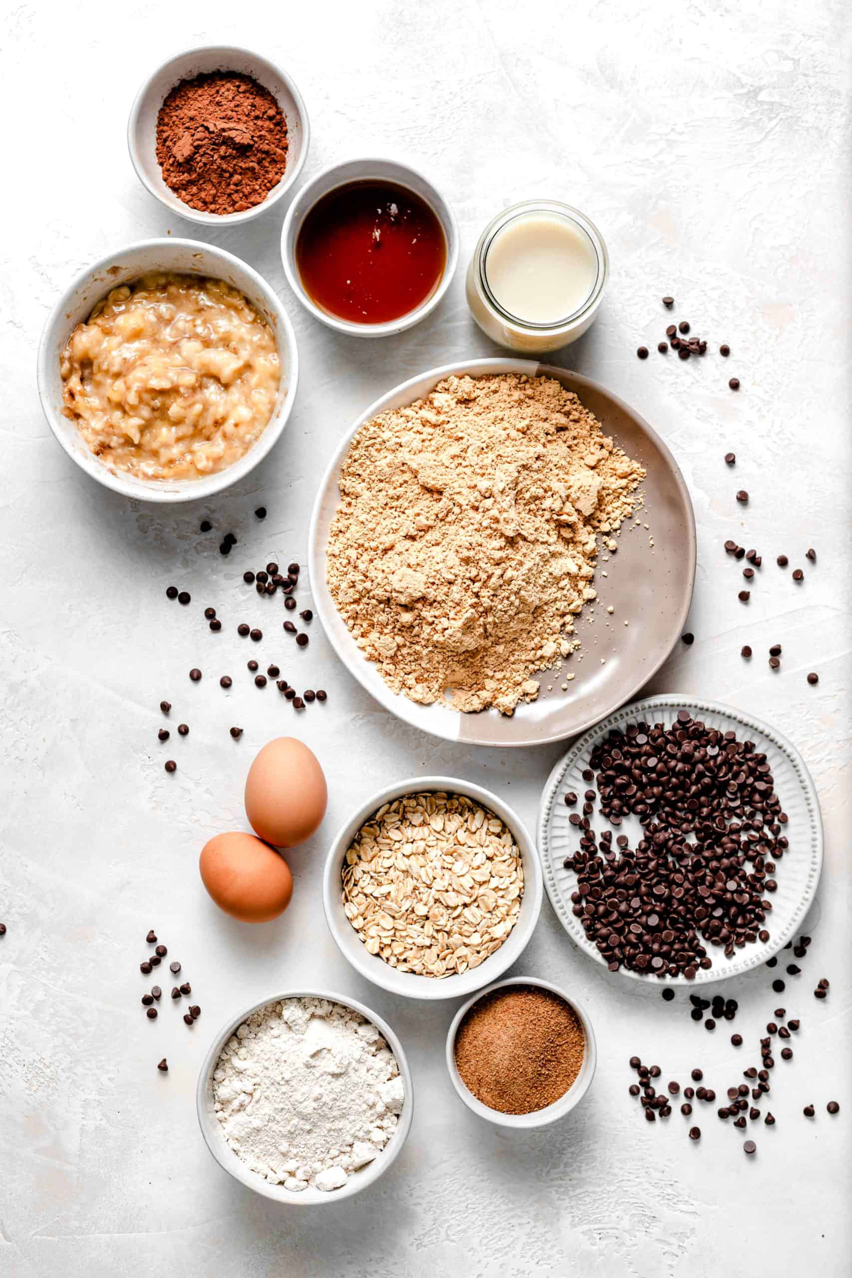 ingredients for healthy chocolate peanut butter banana muffins laid out on a table top