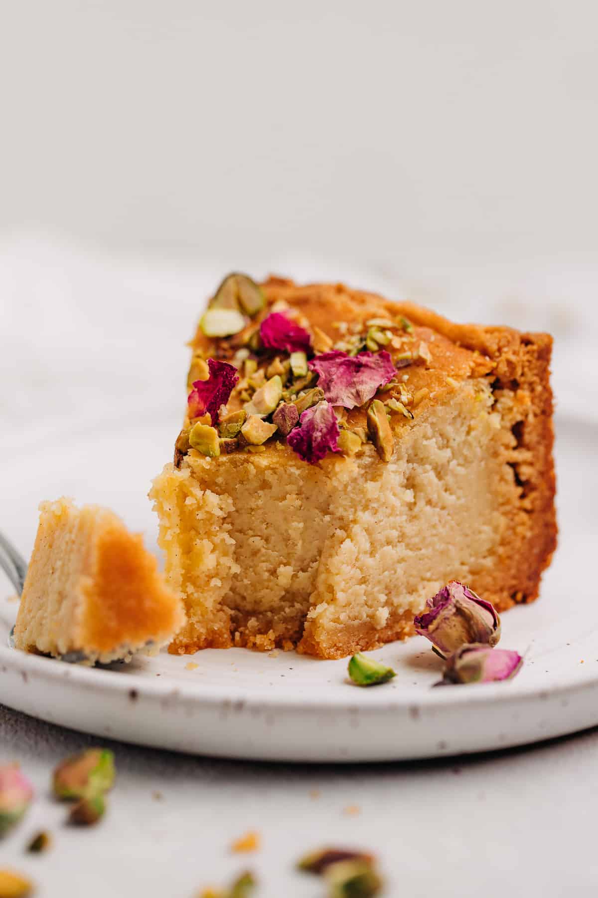 A slice of Persian love cake on a plate with a fork.