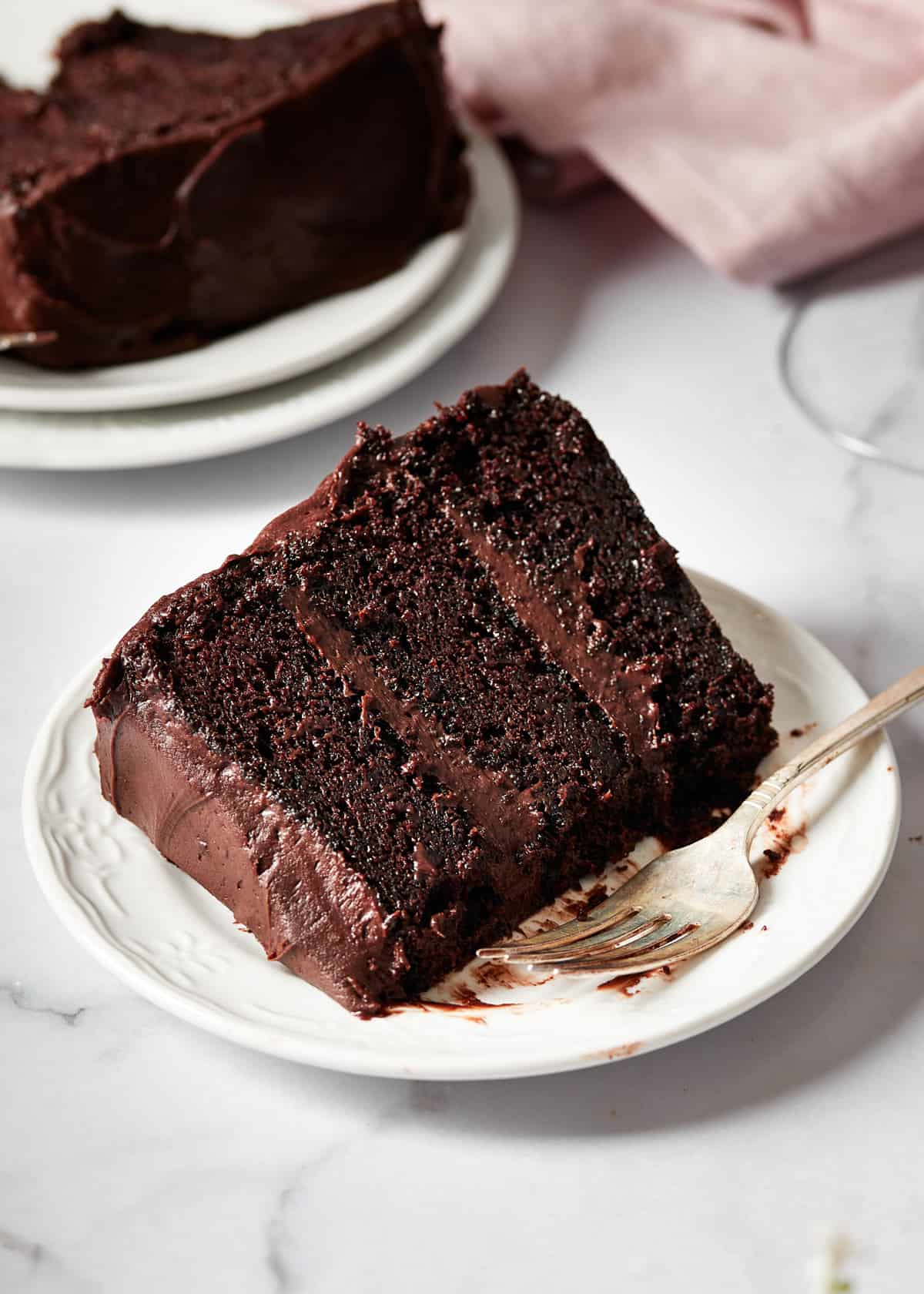 a slice of red wine chocolate cake on a white plate.