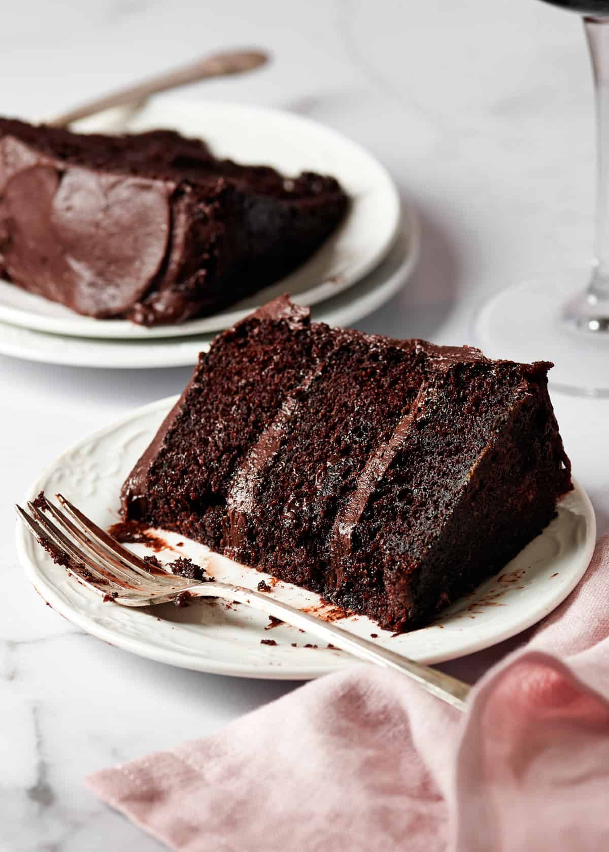 a slice of red wine chocolate cake on a white plate.