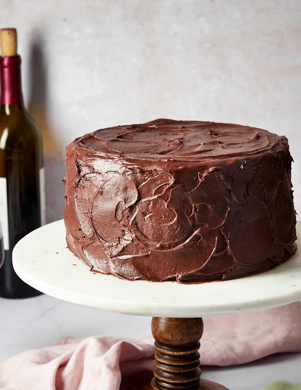 red wine chocolate with chocolate cream cheese frosting on a cake stand.