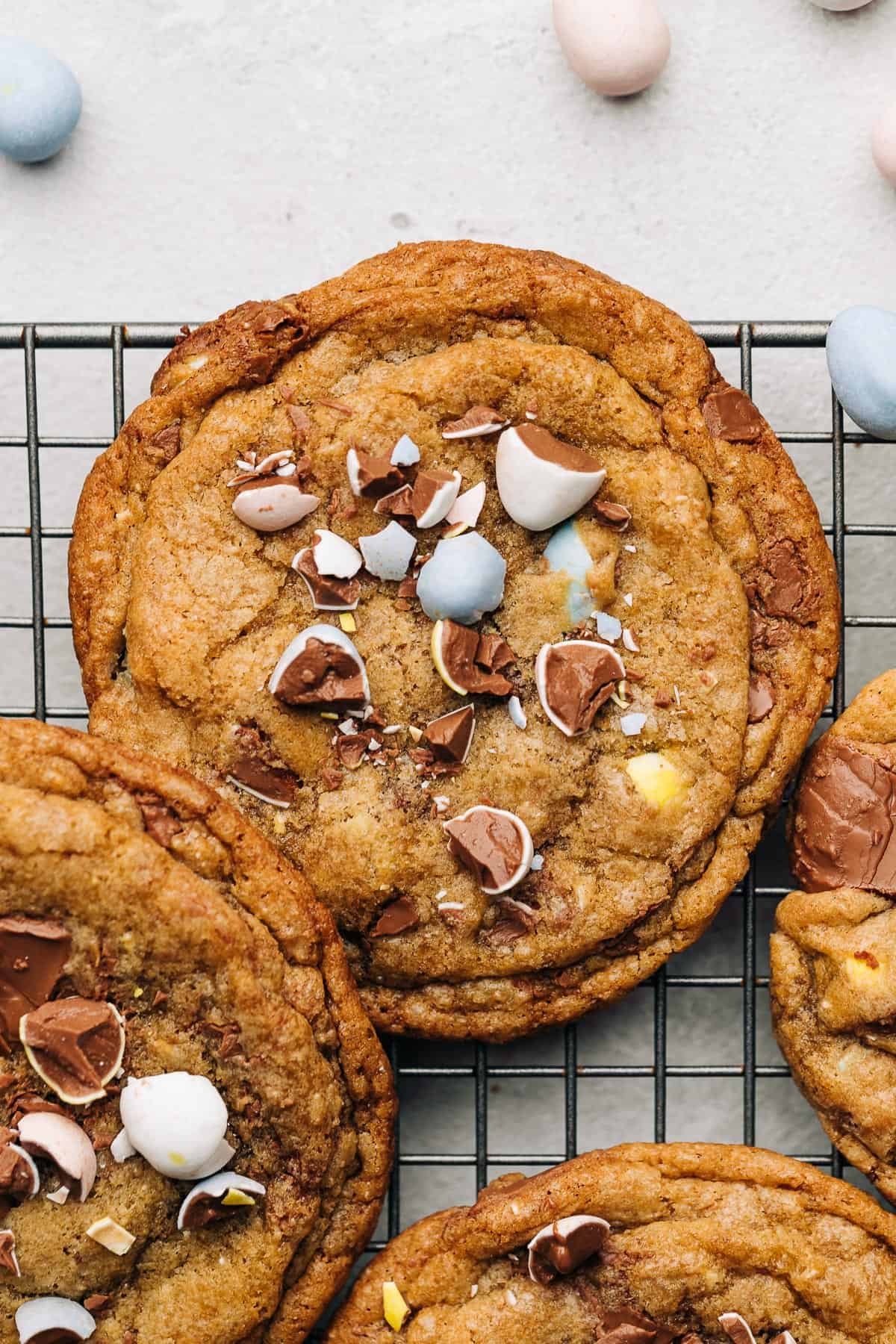 Cadbury Mini Egg milk chocolate chip cookies on a wire cooling rack.