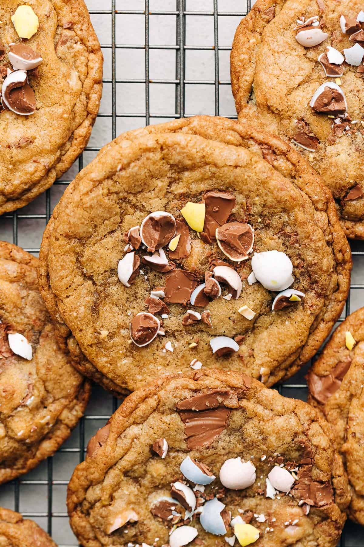 Cadbury mini egg chocolate chip cookies on a wire rack.