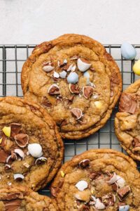 Cadbury Mini Egg chocolate chip cookies on a wire rack.