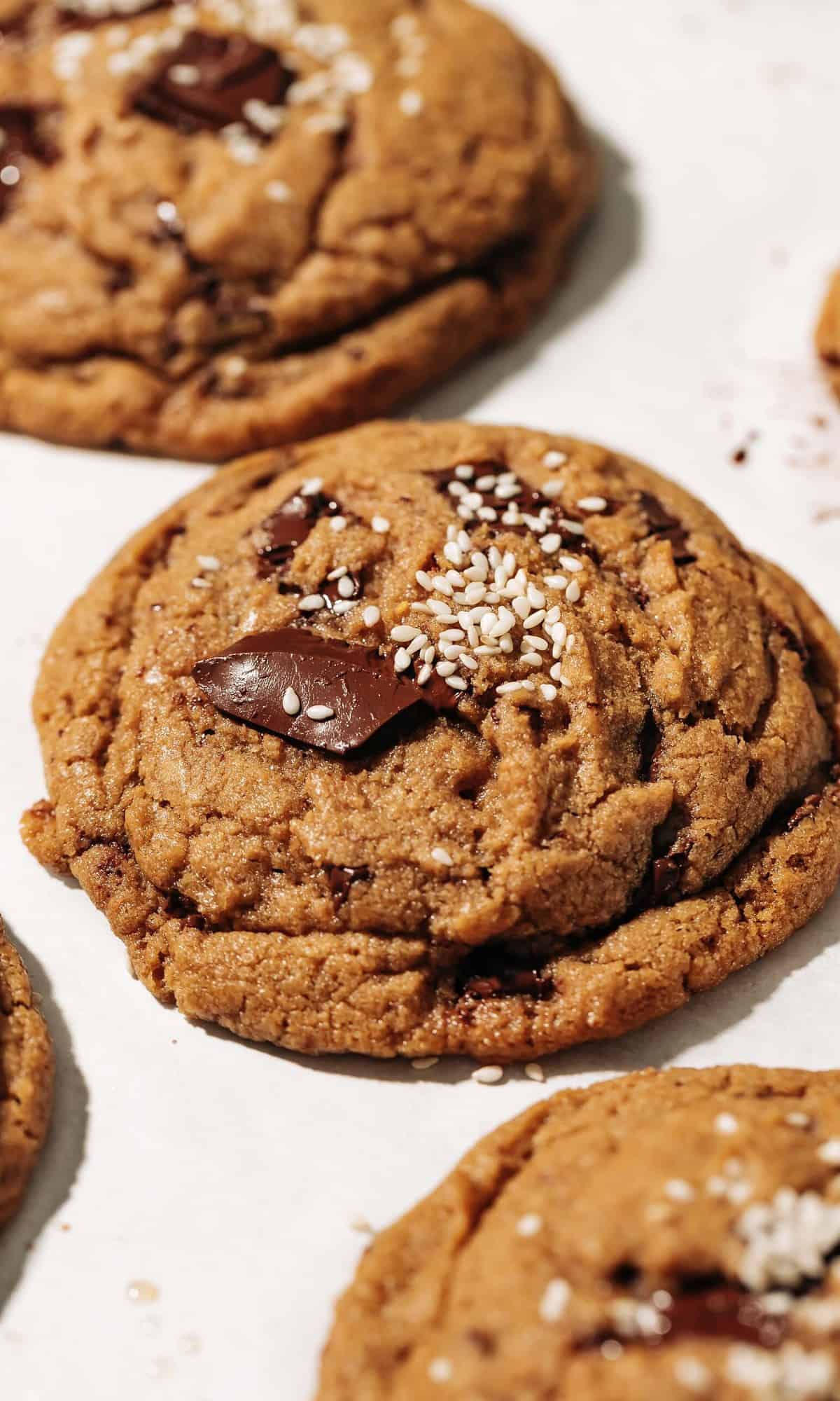 baked chocolate chip tahini cookie on parchment paper.