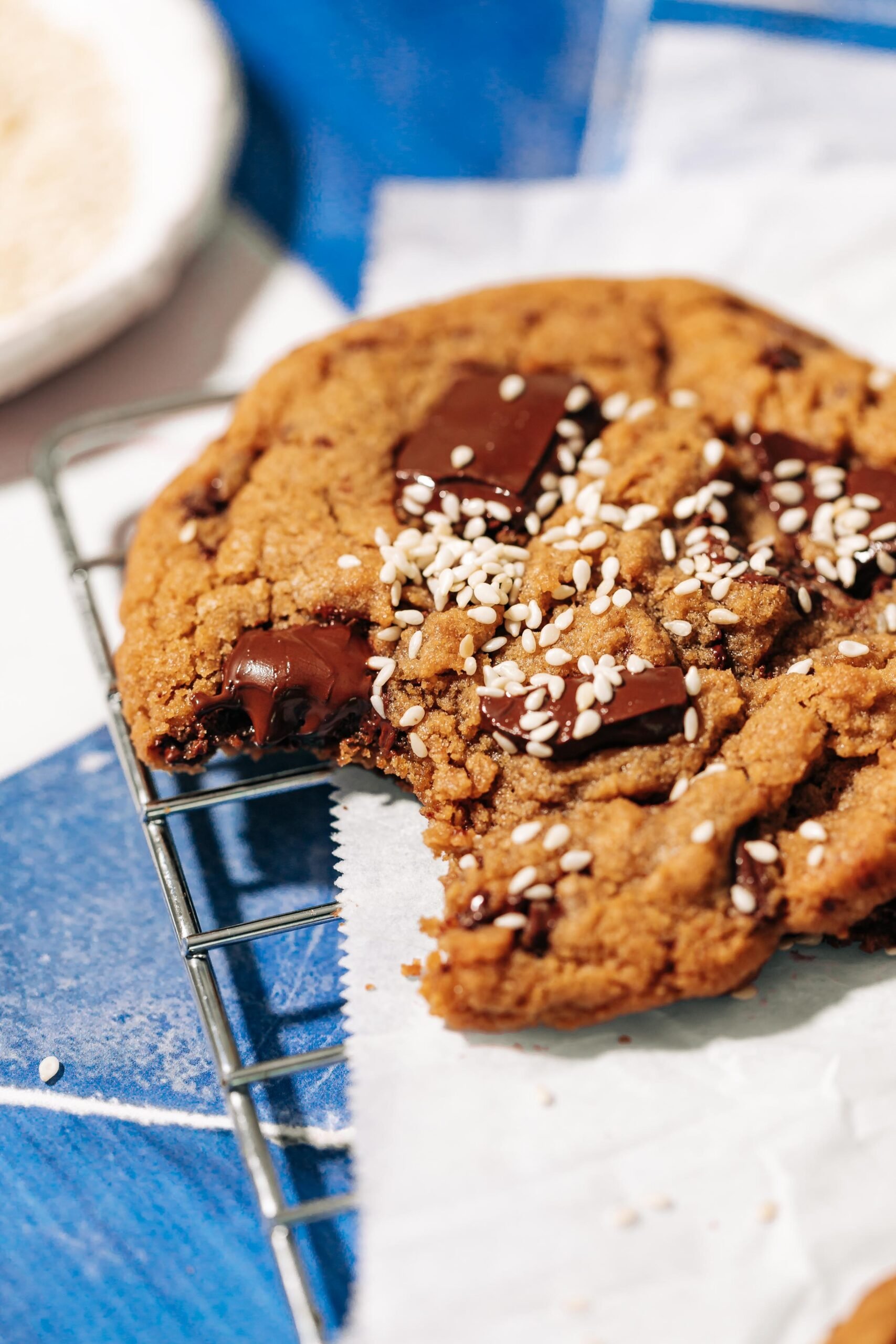 bite shot of a tahini chocolate chip cookie on a wire rack.