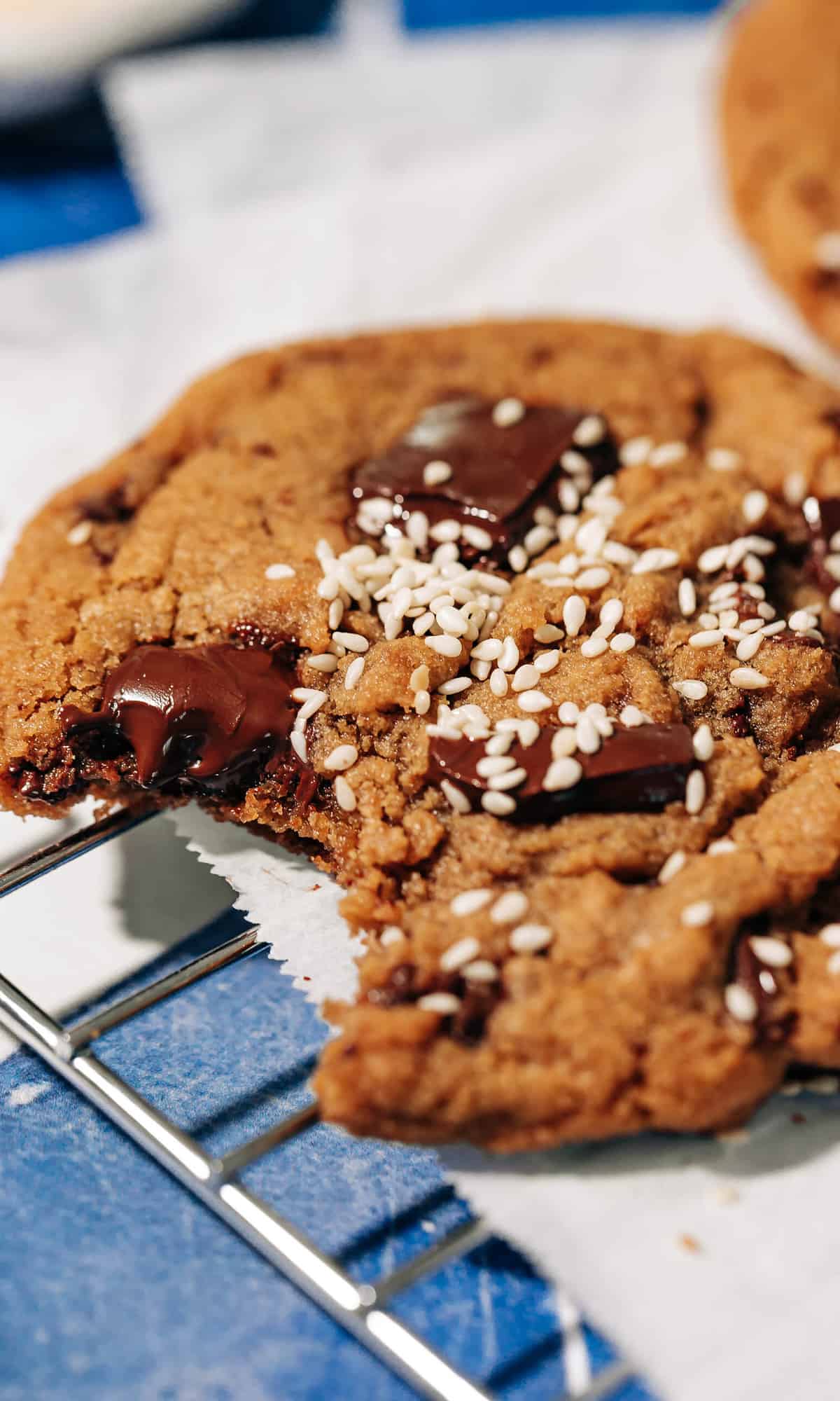 bite shot of a tahini chocolate chip cookie on a wire rack.