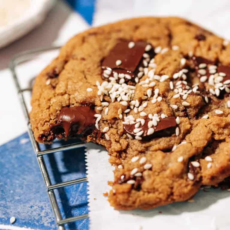 bite shot of a chocolate chip tahini cookie on a wire rack.