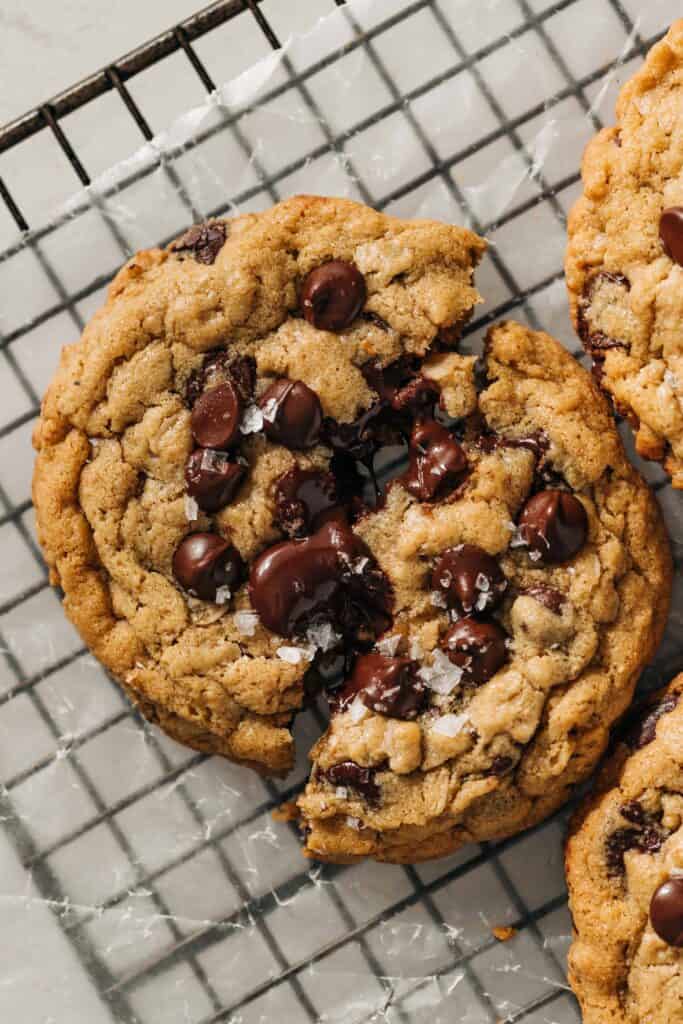 peanut butter oatmeal chocolate chip cookie cut in half on a wire rack.